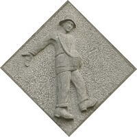 Hardstenen vierkante gevelsteen, op de punt geplaatst, met daarin een afbeelding van een zaaier, in de voorgevel van wat eens de woning was van het hoofd van de R.K. Lagere Landbouwschool.